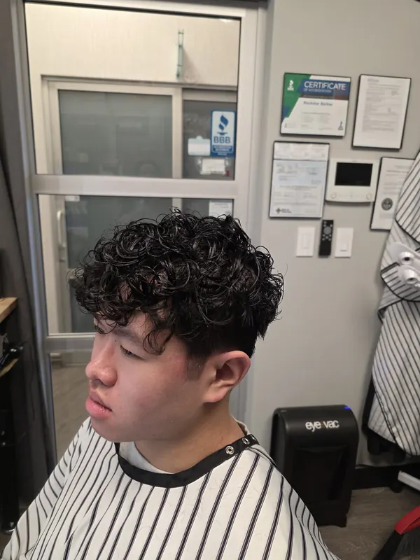 Men's curly perm with a clean taper